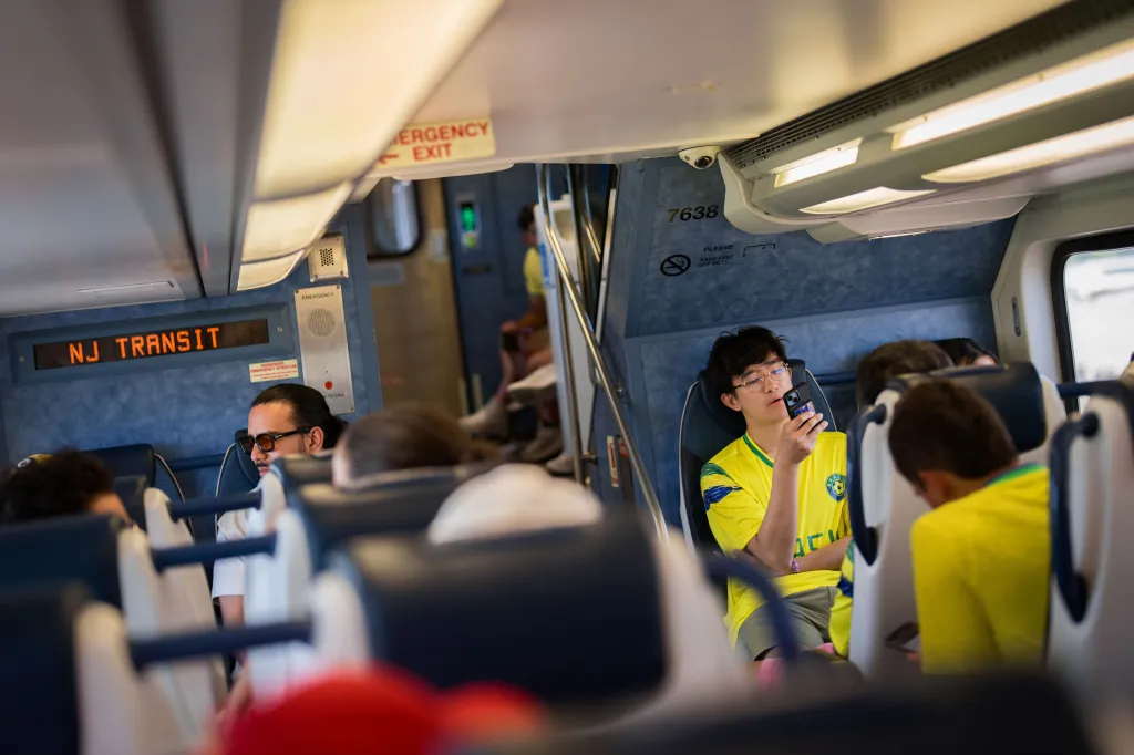 Fans wearing Brazil jerseys riding an NJ Transit train from Secaucus Junction to Meadowlands.
