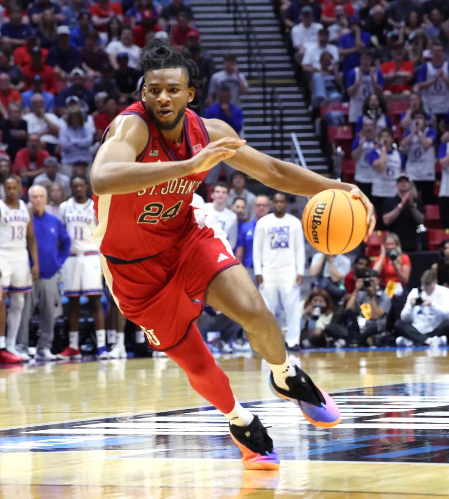 A St. John's Red Storm player dribbling the basketball in a game against the Kansas Jayhawks during the NCAA Tournament.