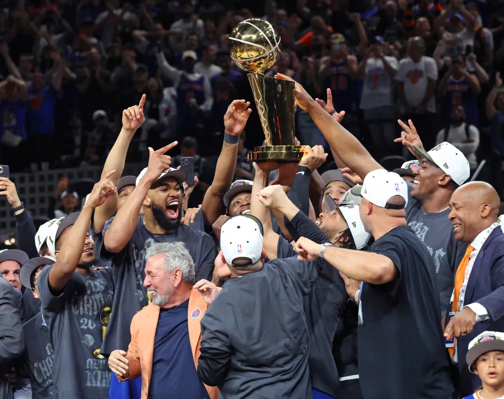 The New York Knicks players and staff celebrate with the Larry O'Brien Championship Trophy after winning Game 5 of the 2026 NBA Finals.