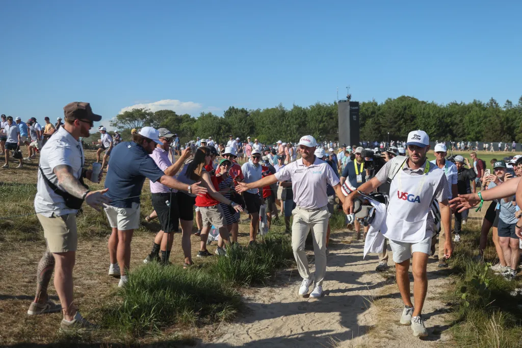 Fans high-five Wyndham Clark as he walks between holes during the 126th U.S. Open Championship at Shinnecock Hills Golf Club
