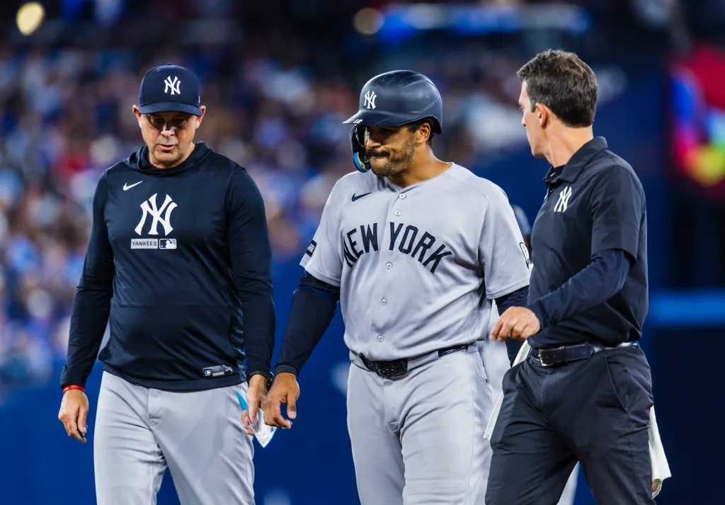 Trent Grisham leaving the game with manager Aaron Boone after injuring himself.
