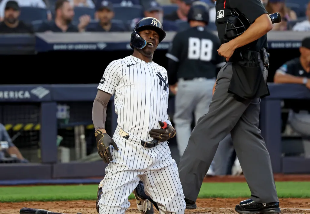 New York Yankees second baseman Jazz Chisholm Jr. on his knees in pain after fouling a ball off his groin.