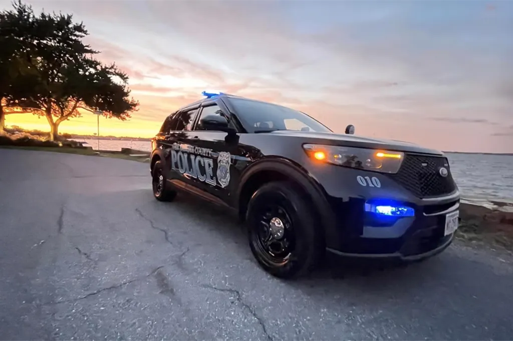 An Anne Arundel County police car with its lights on at dusk.