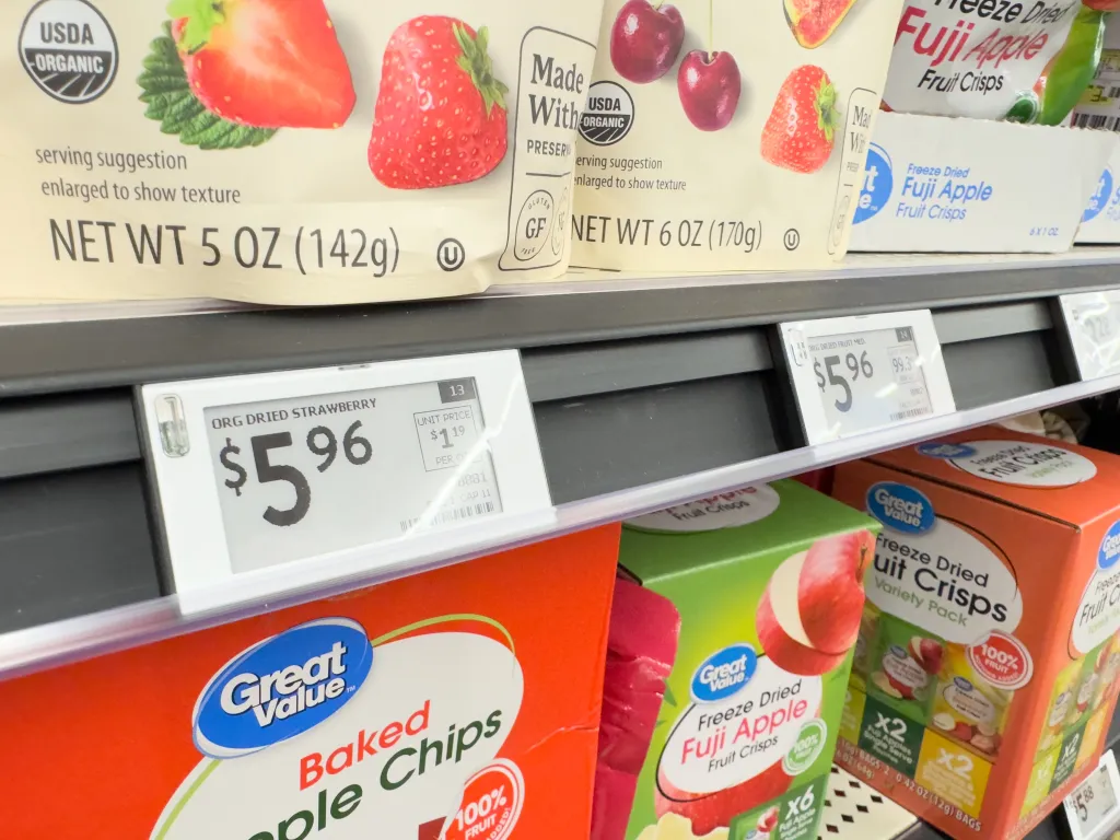Digital price tags displaying $5.96 for dried fruit on a supermarket shelf.