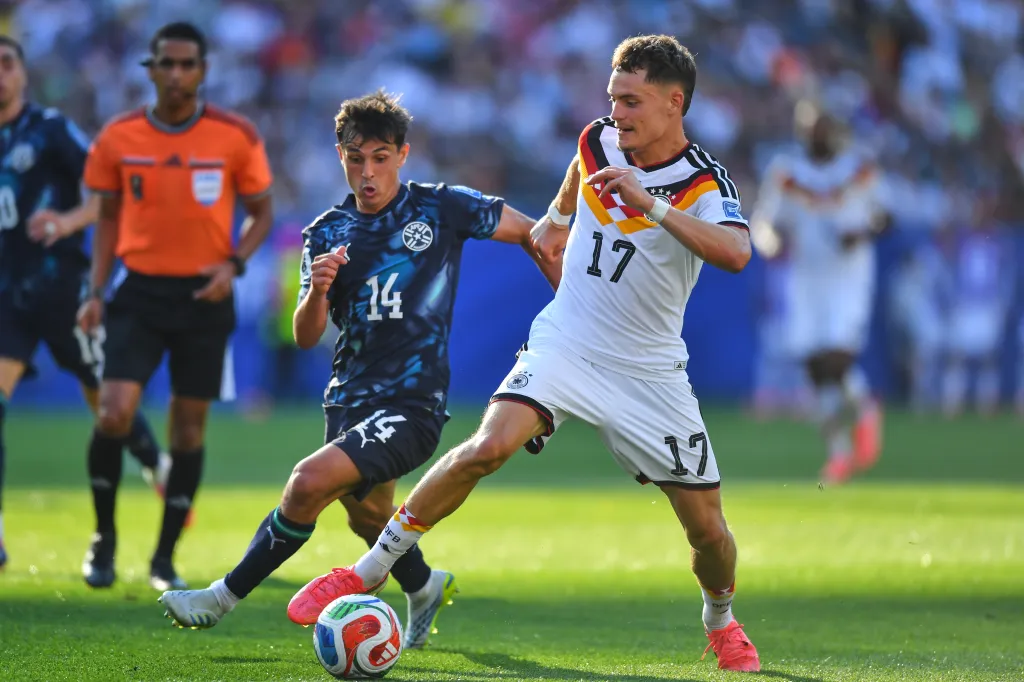 Germany's Florian Wirtz and Paraguay's Andres Cubas battle for the ball during a World Cup match.