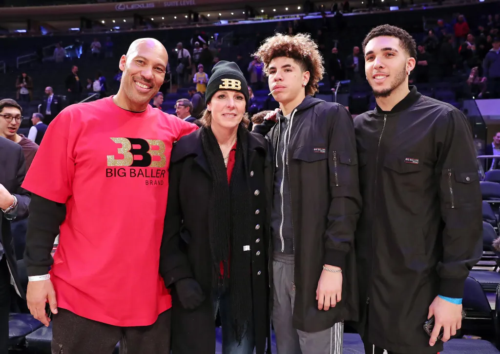The Ball family posing for a picture at a basketball game.