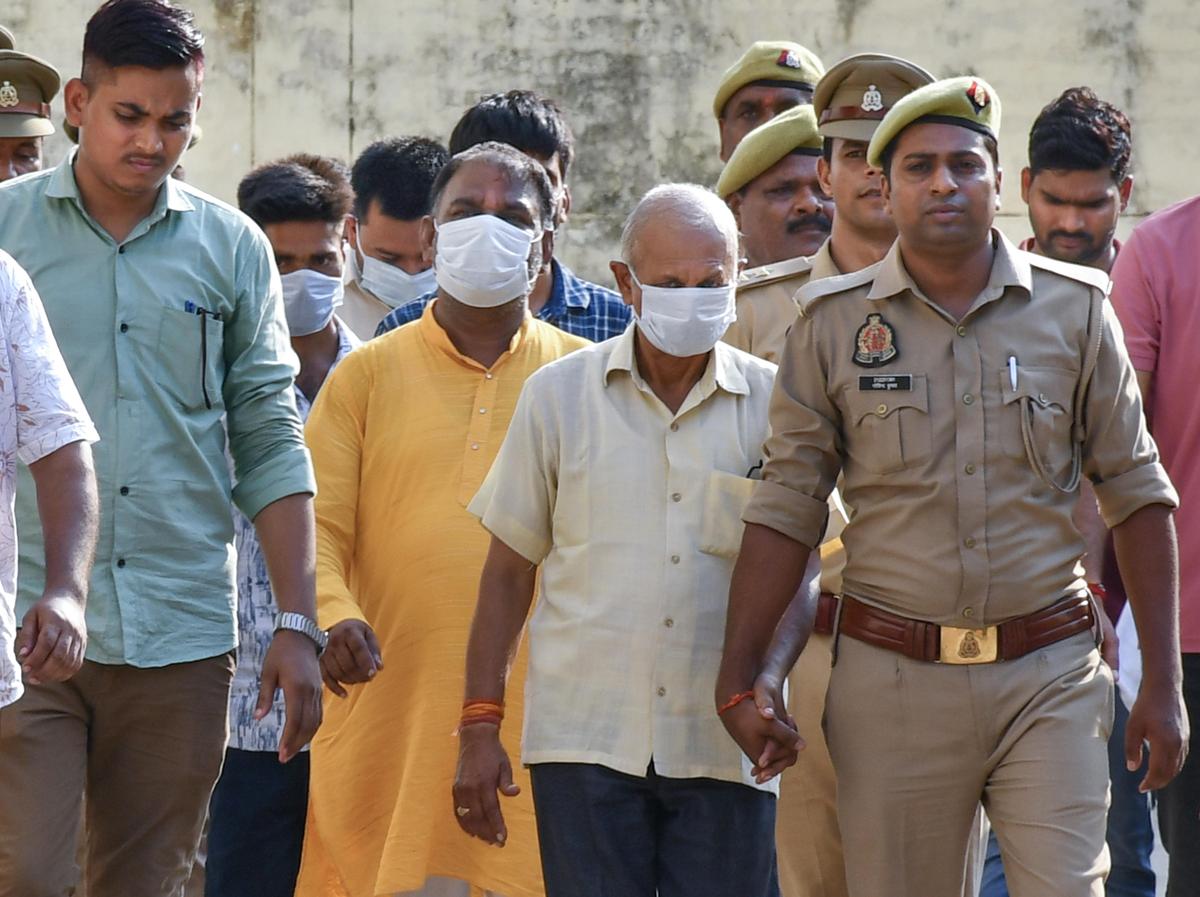 Police personnel escort accused to a court in connection with the alleged embezzlement of Ram Temple donation funds, in Ayodhya, on Friday, June 26, 2026.