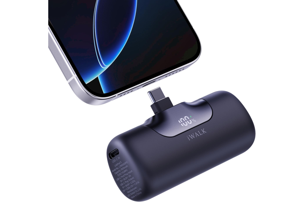 An iWALK portable charger with a USB-C plug connected to a smartphone, displaying 100% charge.