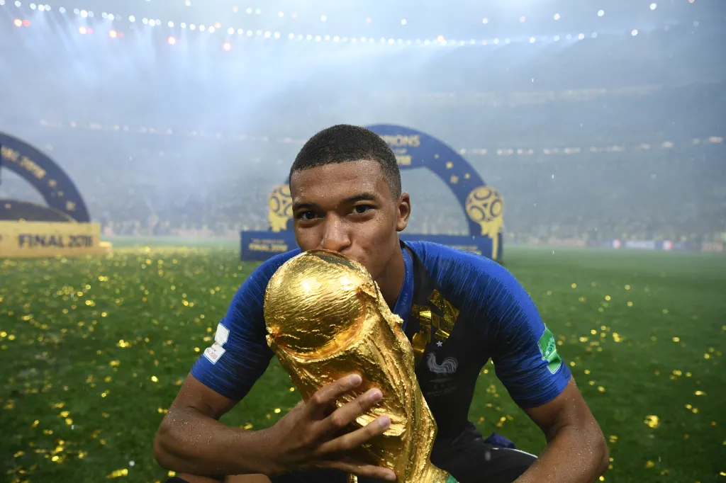 Kylian Mbappe kissing the World Cup trophy.