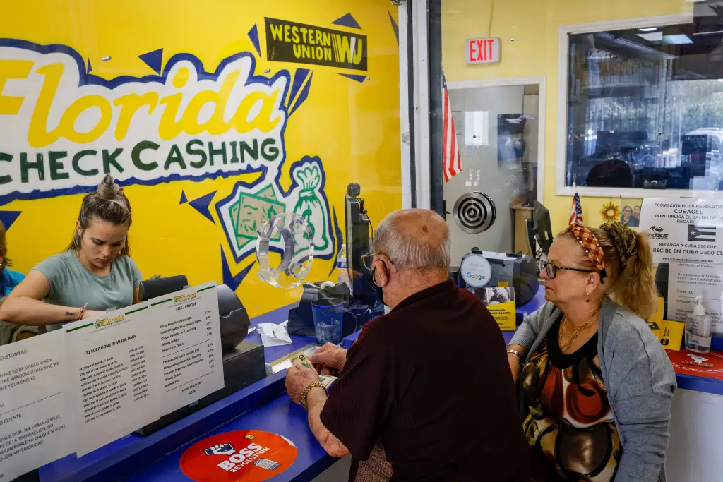 Two people making a money transaction at a Western Union counter.