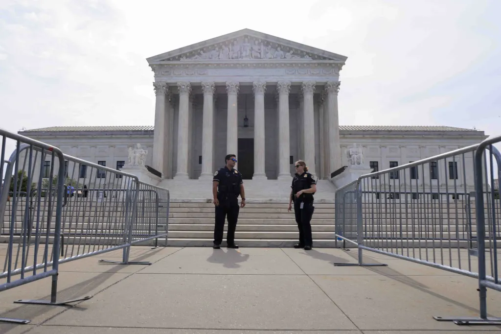 Police officers standing in front of the US Supreme Court building.
