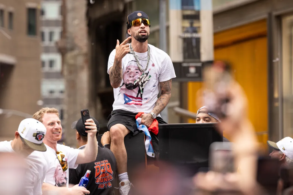Jose Alvarado celebrating on a parade float during the New York Knicks' 2026 NBA Championship parade.