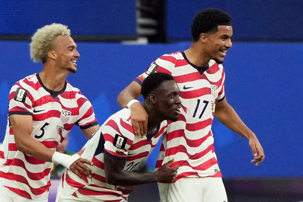 Folarin Balogun celebrating with Antonee Robinson and Malik Tillman after scoring a goal for the U.S.