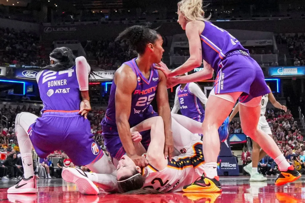 Phoenix Mercury forward Alyssa Thomas (25) scrambles to get up over Indiana Fever guard Caitlin Clark (22) on Wednesday, June 24, 2026, during a game at Gainbridge Fieldhouse in Indianapolis. The Phoenix Mercury defeated the Indiana Fever, 111-109.