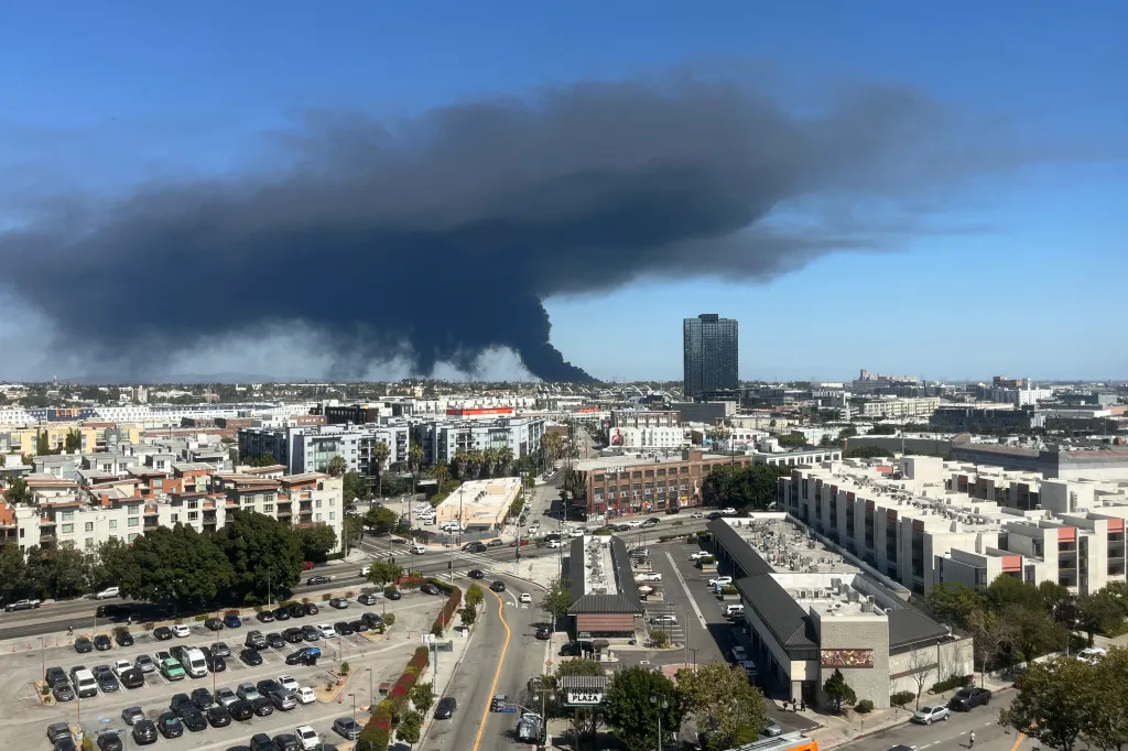 Black smoke rises above downtown Los Angeles from a warehouse fire in Boyle Heights.