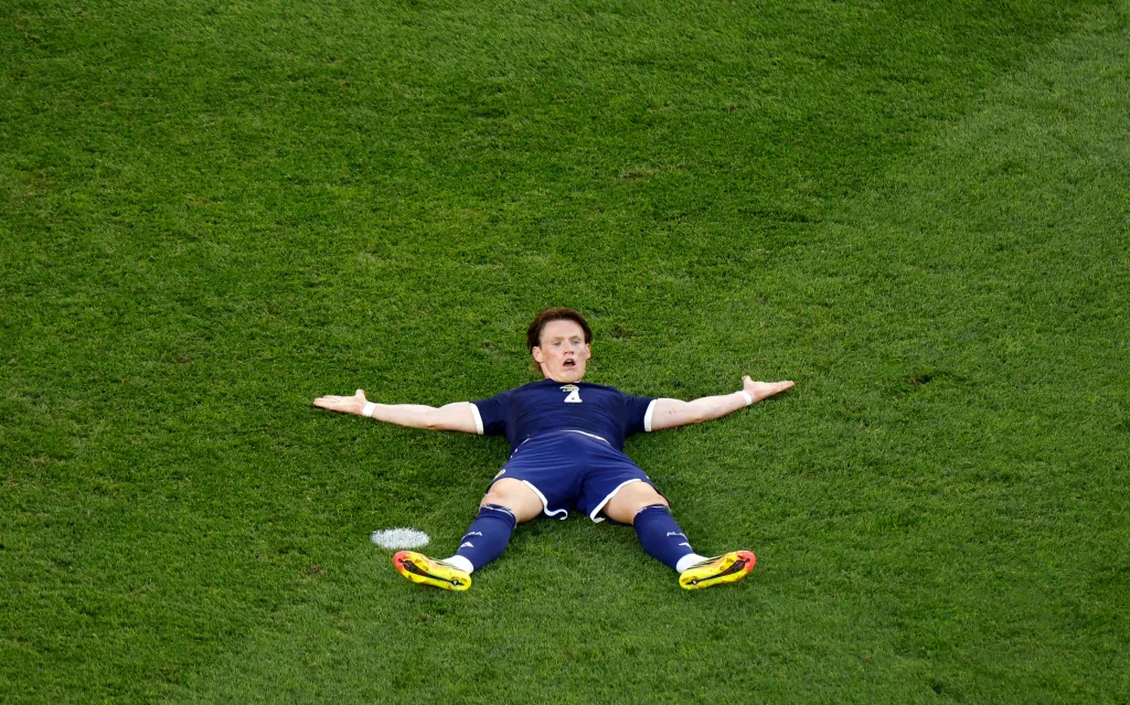Scotland's Scott McTominay reacts while lying on the grass after a referee does not award him a penalty.