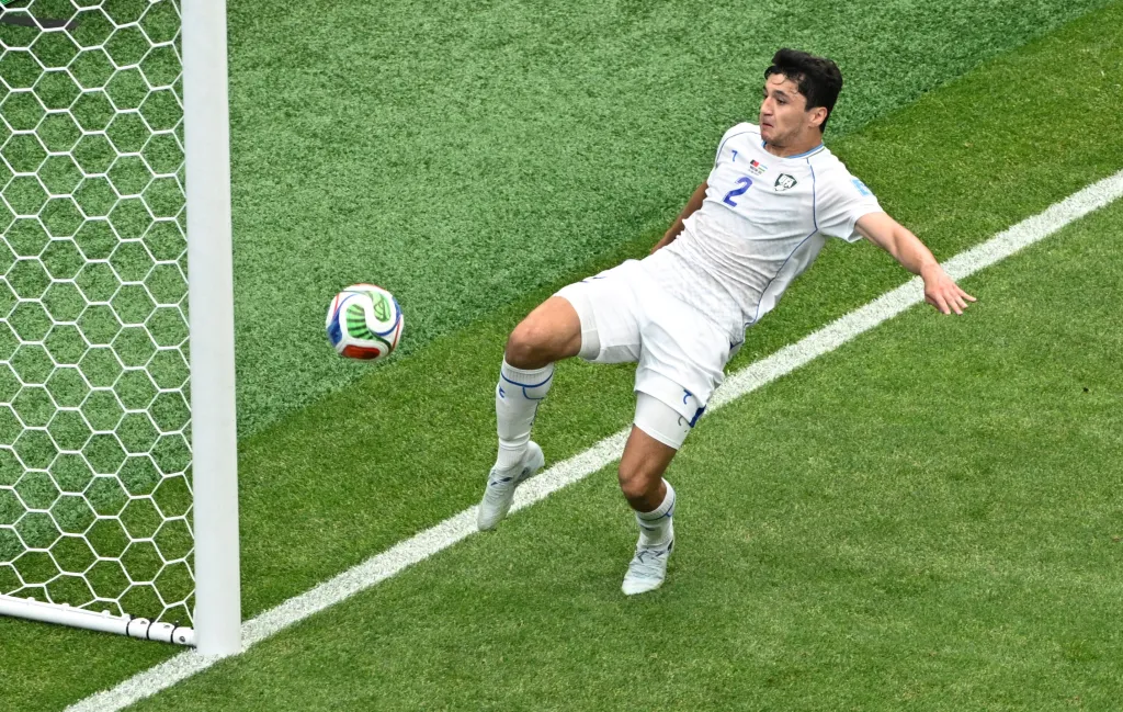 Uzbekistan's Abdukodir Khusanov clears the ball off the goal line.