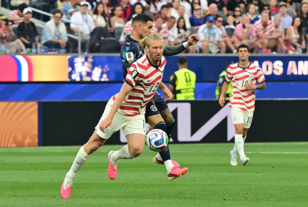 US defender #13 Tim Ream and Paraguay's forward #09 Antonio Sanabria fight for the ball during the 2026 World Cup Group D football match.