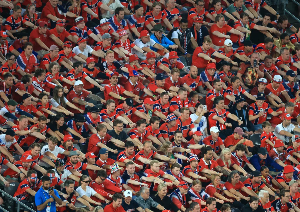 Fans of Norway cheer for their team during a football match.
