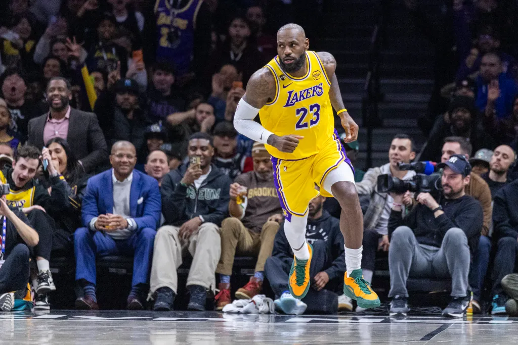 LeBron James in his yellow and purple Lakers uniform running on the basketball court.