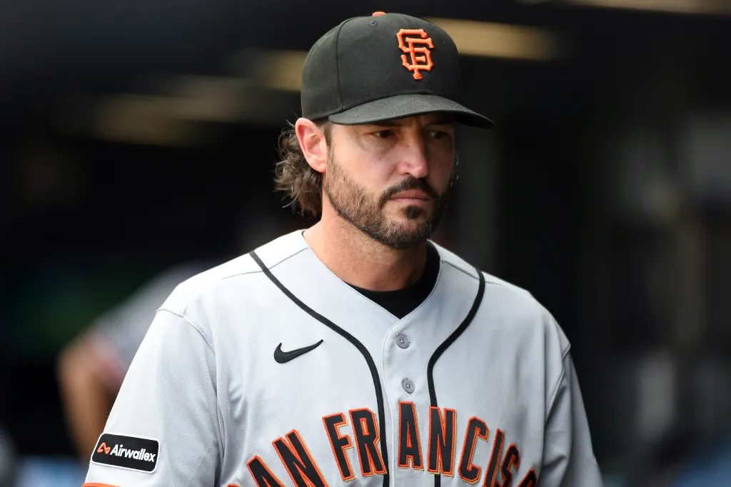 San Francisco Giants baseball player wearing a black cap with an orange "SF" logo.