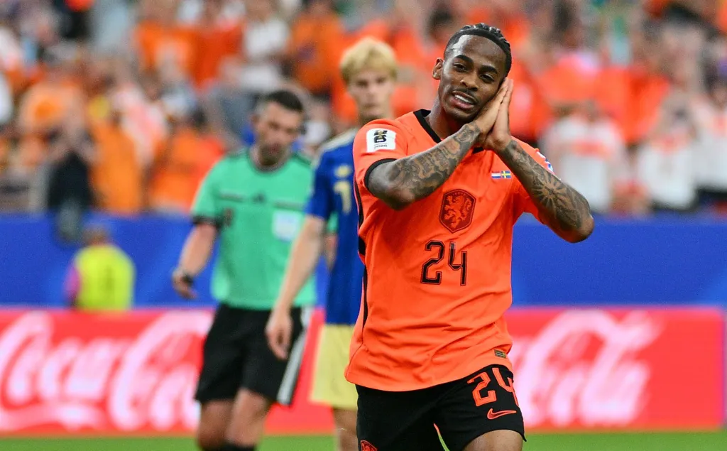 A Netherlands player celebrating by making a sleeping gesture with his hands against his face.