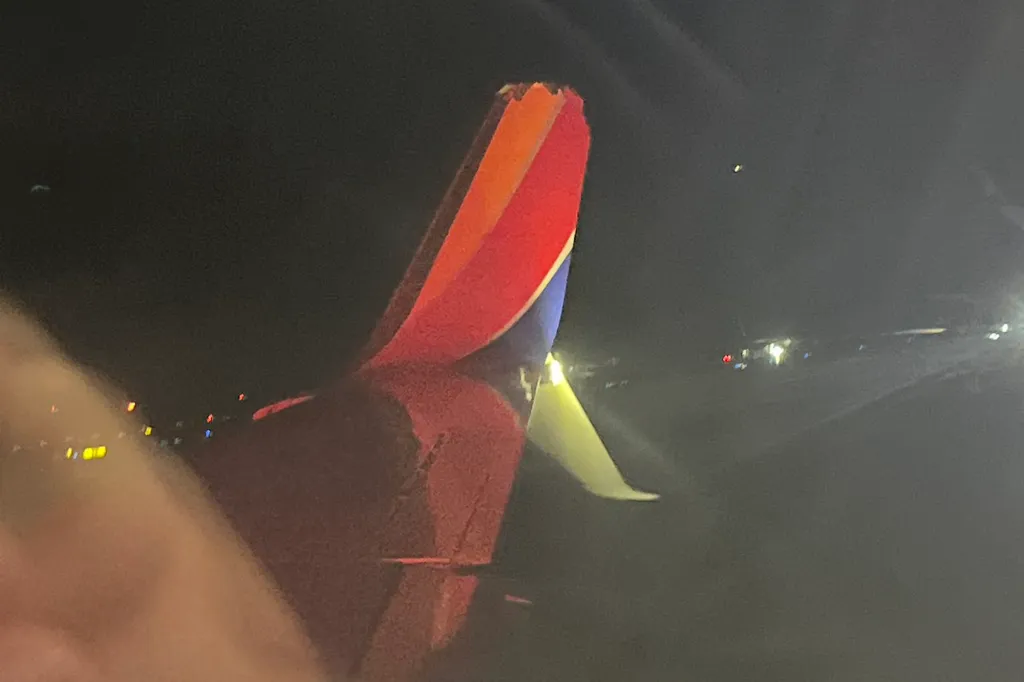 Tail of a Southwest Airlines plane with visible damage from an incident at an airport.