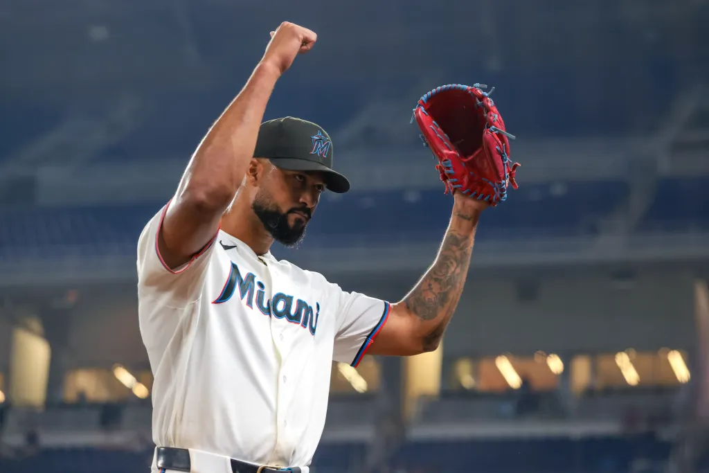 Miami Marlins pitcher Sandy Alcantara raises his arms to acknowledge fans.