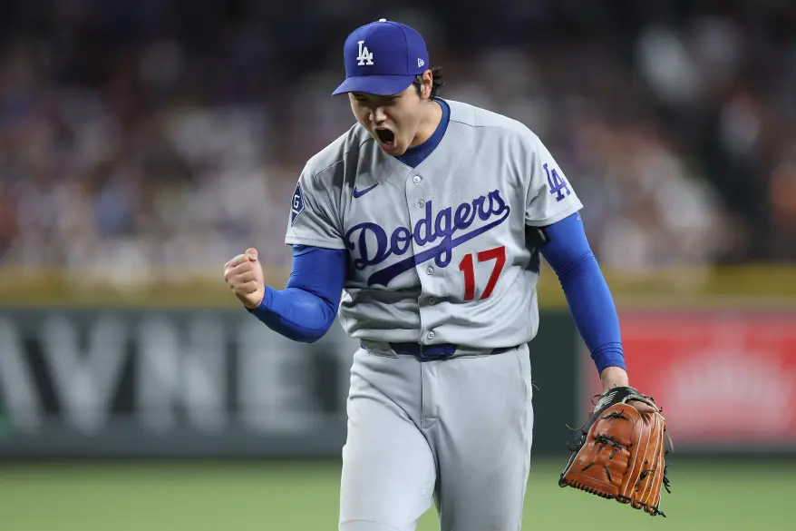 Los Angeles Dodgers pitcher Shohei Ohtani celebrates while holding his glove.