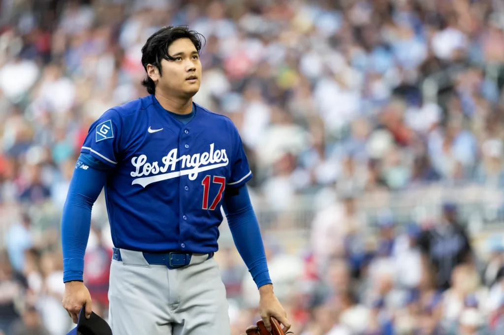 Los Angeles Dodgers player Shohei Ohtani looking up in a blue jersey with number 17.