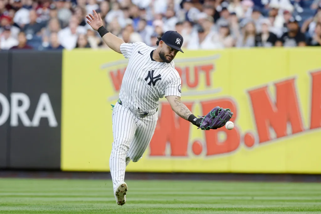 Jasson Dominguez #24 of the New York Yankees can't hold onto a ball hit for a double in the third inning by Blake Dunn of the Cincinnati Reds at Yankee Stadium on June 19, 2026 in New York City.