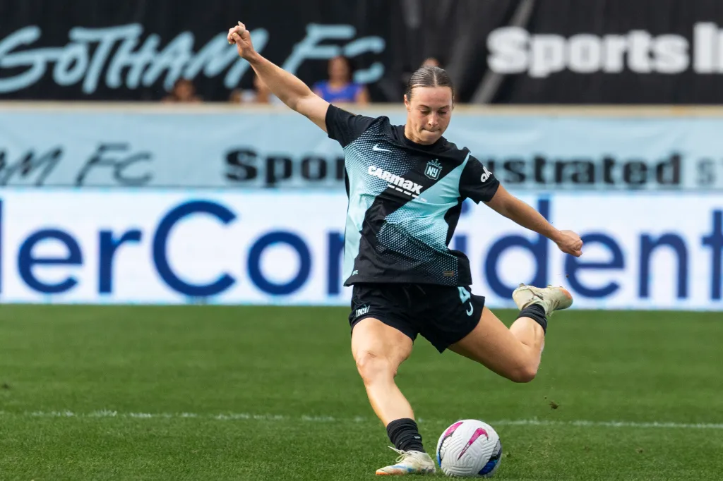 Lilly Reale kicking a soccer ball while playing against the Houston Dash.