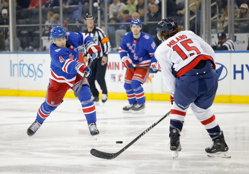 Braden Schneider of the New York Rangers takes a shot as Sonny Milano of the Washington Capitals defends during the third period.