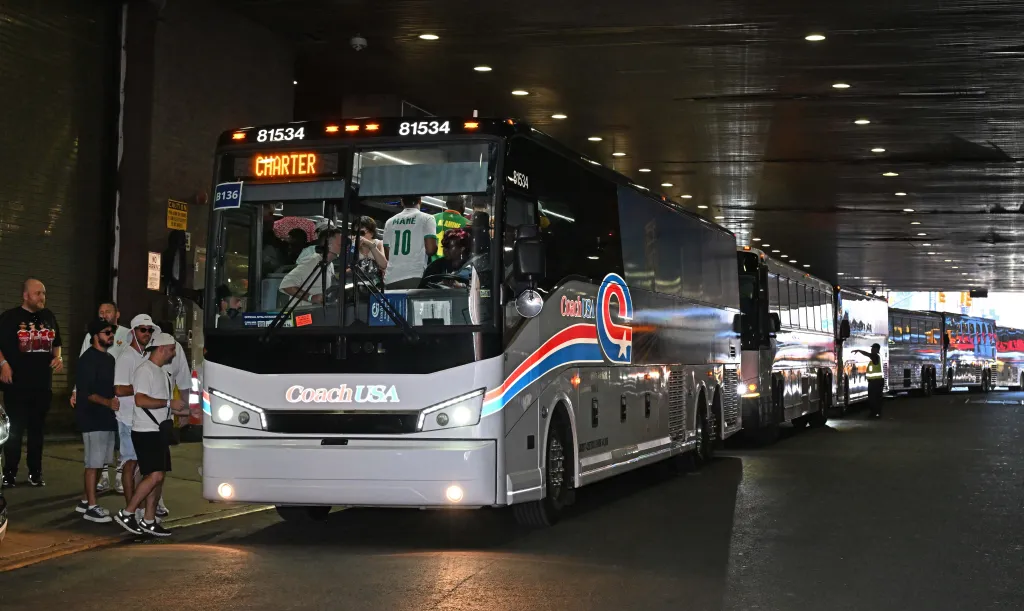 Spectators board Coach buses at the Port Authority.