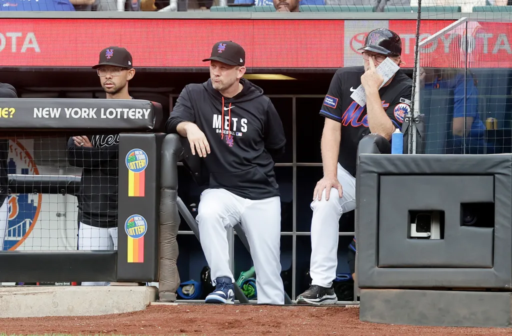 New York Mets interim manager Andy Green, bench coach Kai Correa, and third base coach Tim Leiper in the dugout.