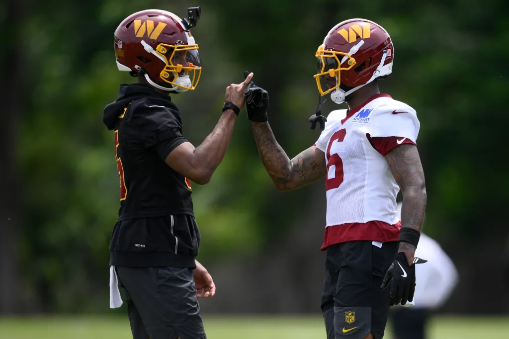 Jayden Daniels and Dyami Brown touching fists.