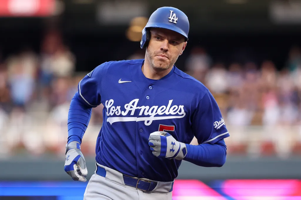 A Dodgers baseball player in a blue uniform and helmet running.