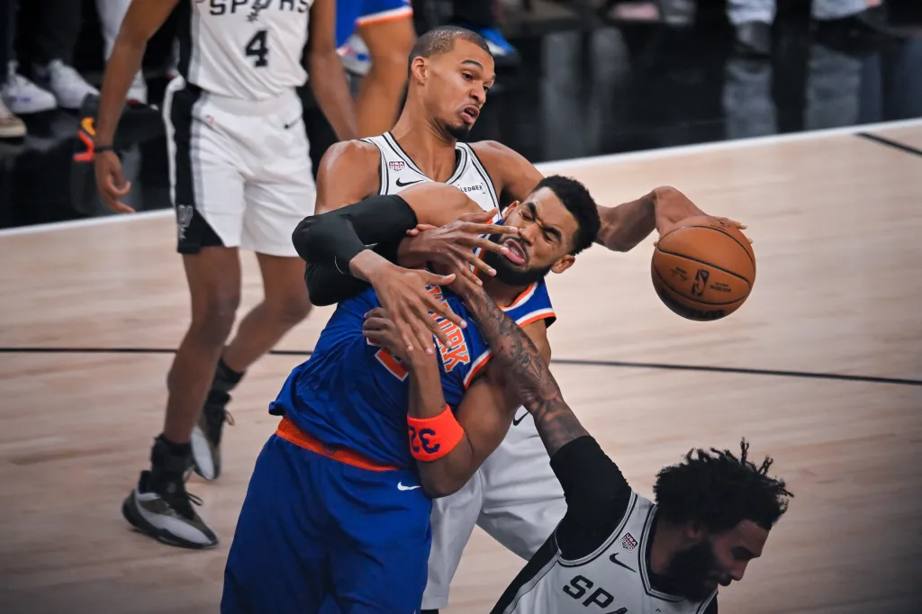 Victor Wembanyama and Karl-Anthony Towns fighting for the basketball.