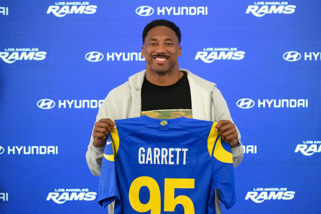 Myles Garrett holding up a Los Angeles Rams jersey with his name and number 95.