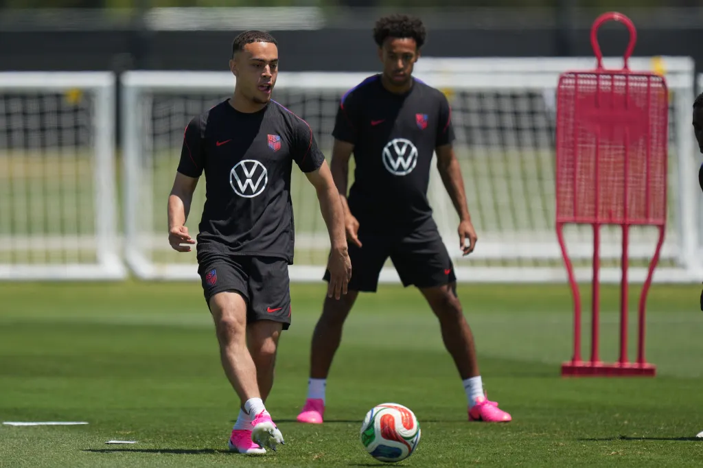 Sergino Dest and Tyler Adams on a soccer field.