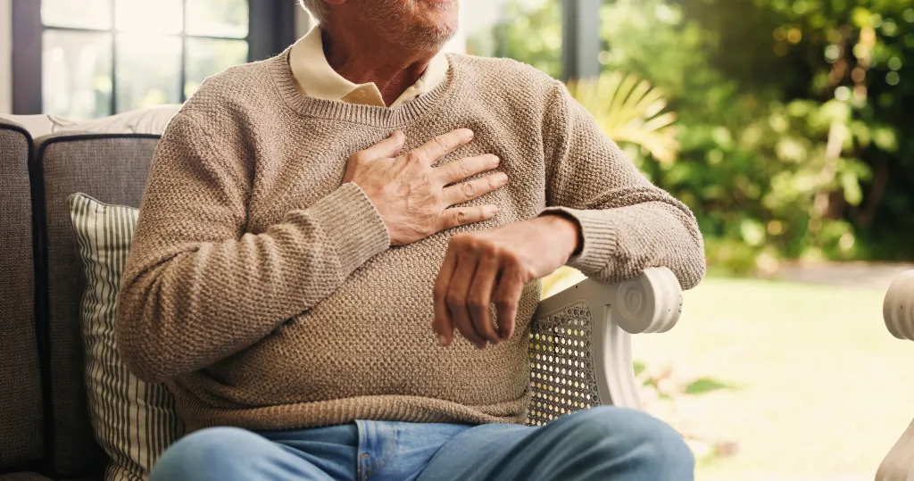 Senior man experiencing chest pain at home.