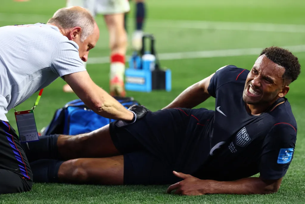 Auston Trusty gets tended to by a trainer after injuring his ankle in the USMNT's loss to Turkey.