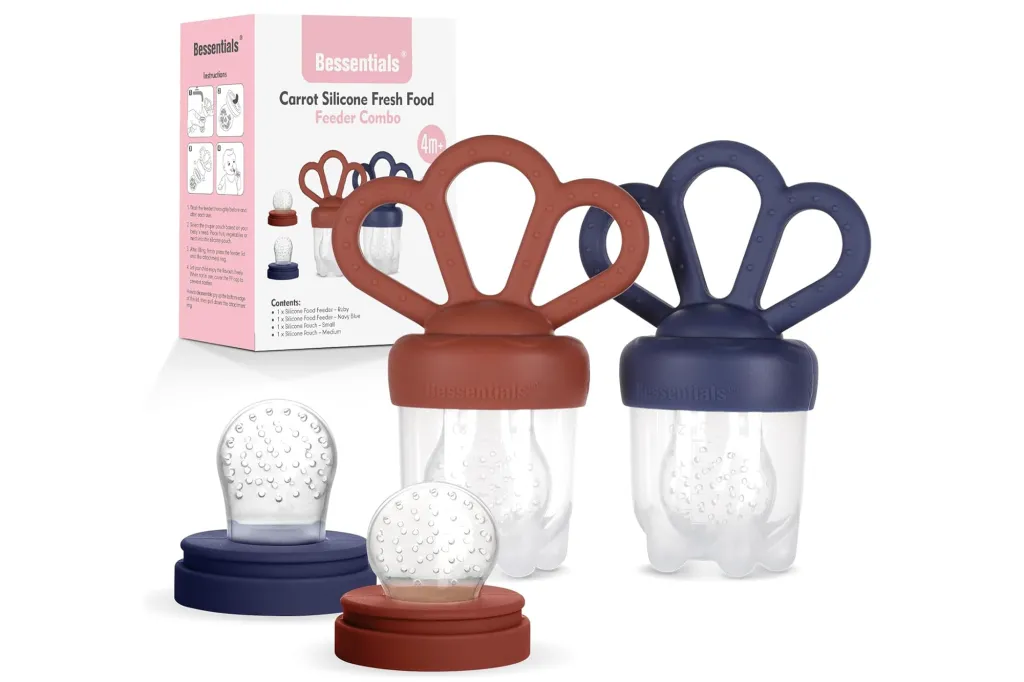 Two Bessentials Carrot Silicone Fresh Food Feeder Combos, one in ruby and one in navy blue, with a box of instructions and contents in the background.