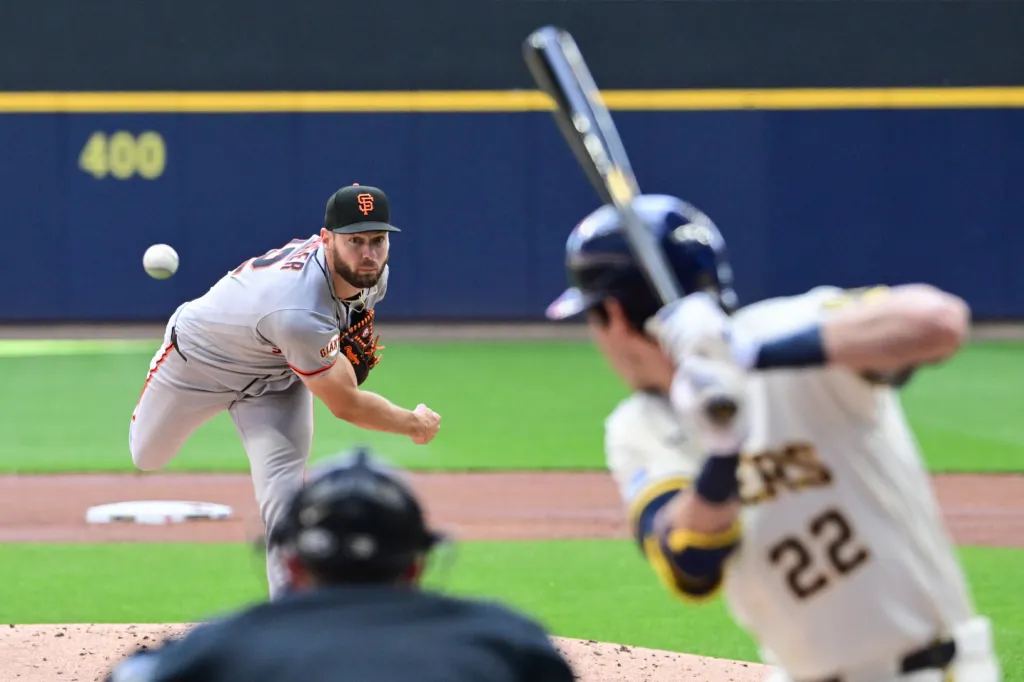Baseball pitcher Adrian Houser throwing a pitch to a batter.