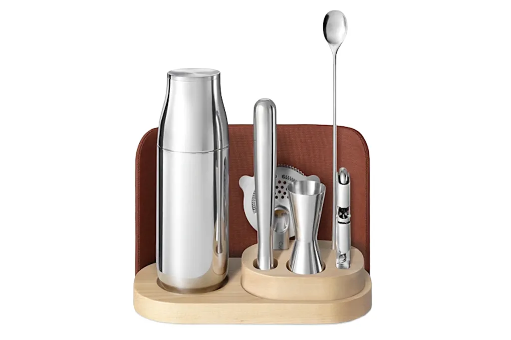 Bar set with a shaker, jigger, strainer, muddler, and spoon in a wooden stand.
