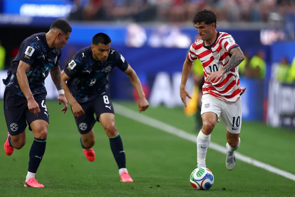 Christian Pulisic rushes up field as Juan Jose Caceres and Diego Gomez defend during the USMNT's World Cup-opening win over Paraguay.