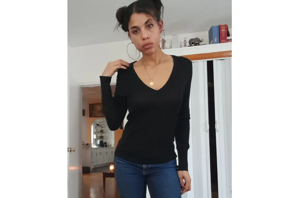 A woman in a black top and jeans.