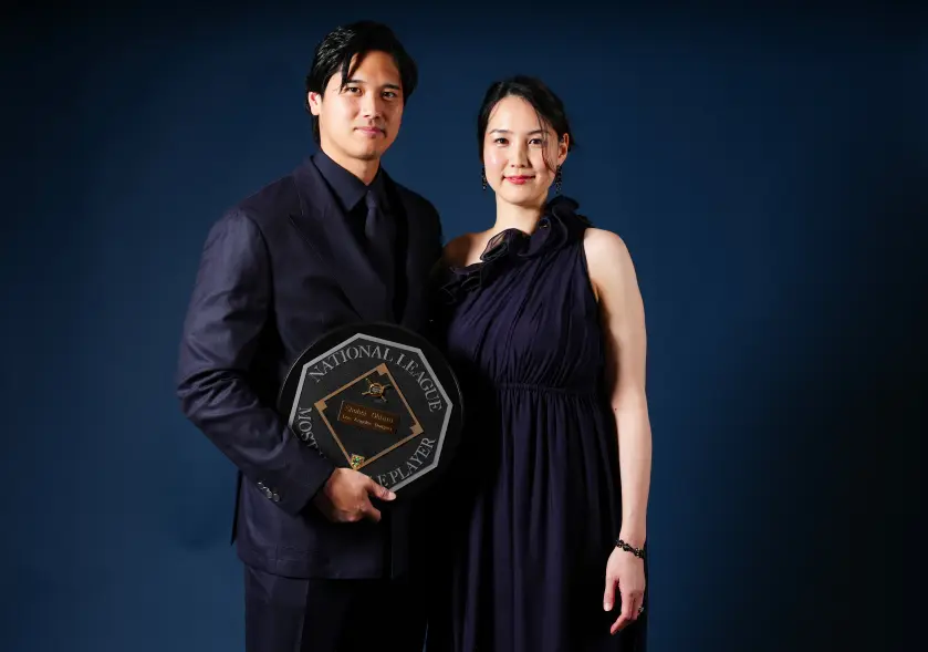 Shohei Ohtani holding an award, standing next to his wife Mamiko.