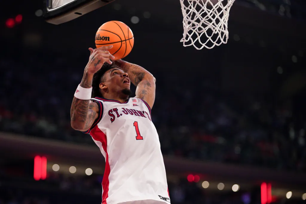 A St. John's player shoots a basketball towards the hoop.