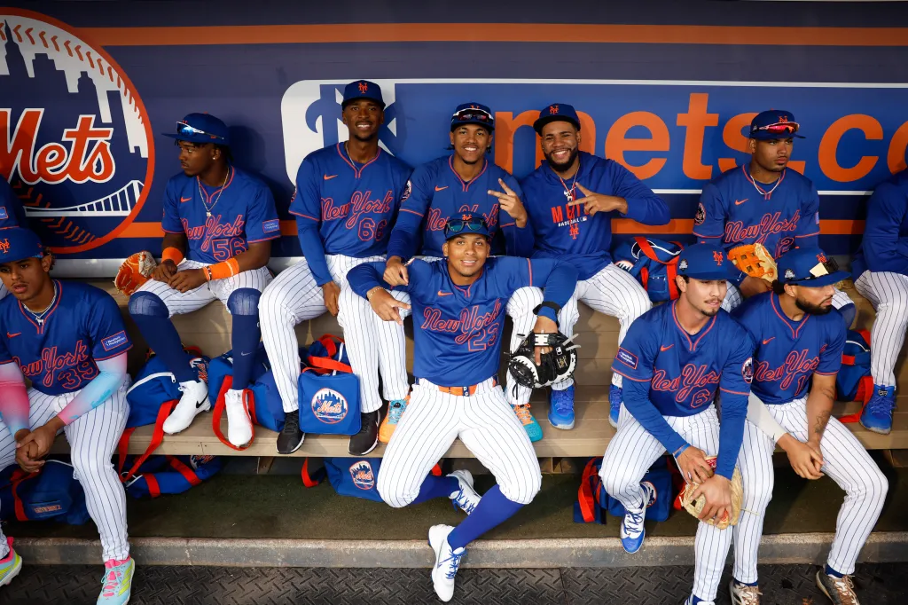 A group of uniformed baseball players in the dugout.